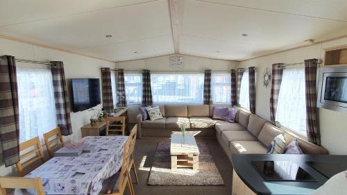 ein Wohnzimmer mit Sofa und Tisch in der Unterkunft Luke's Hideaway at Seal Bay Resort in Selsey