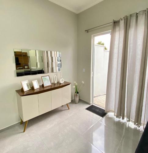 a living room with a dresser and a large window at Casa do Lago da Dinda 2 in Espirito Santo Do Pinhal