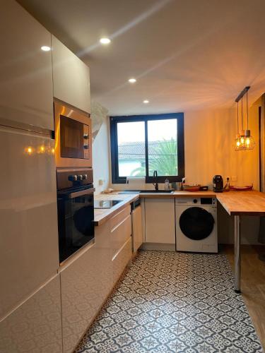 - une cuisine avec des appareils blancs et une table en bois dans l'établissement Charmant appartement Bordeaux, à Bordeaux