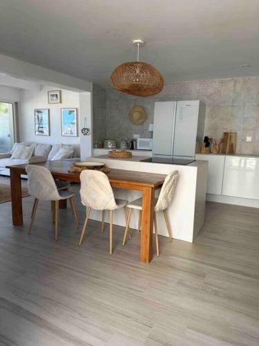 a kitchen with a wooden table and chairs in a kitchen at White Sand, Splendid 1 bedroom beachfront, Nettle Bay Beach Club in Baie Nettle