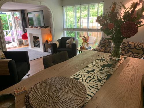 a living room with a wooden table with a vase of flowers at Gezellige ruime Cottage, privé, 2 slaapkamers, hond welkom! in Hattemerbroek