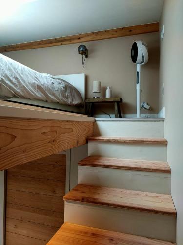 - une chambre avec des escaliers menant à un lit dans l'établissement Le petit Cocon du Lac, à Lacanau