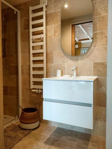 une salle de bain avec un lavabo et un miroir dans l'établissement Le petit Cocon du Lac, à Lacanau
