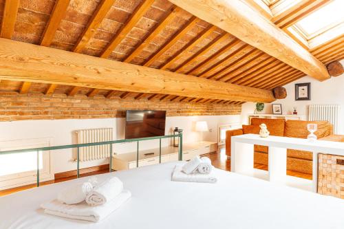 una habitación con una cama y una sala de estar en Mansarda Magellano - Parcheggio Auto, en Ferrara