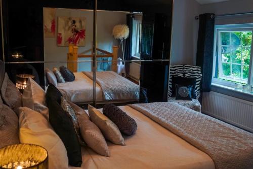 a bedroom with two beds and a mirror at Country Cottage Annex (The Cwtch) in Gilwern