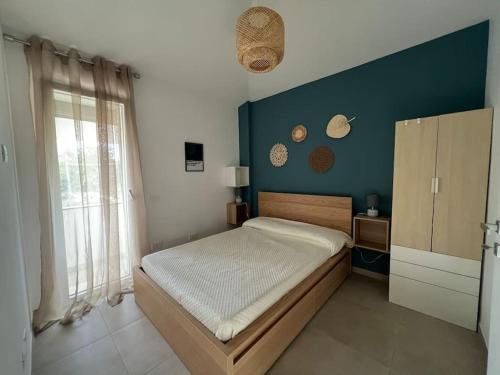 ein Schlafzimmer mit einem Bett und einer blauen Wand in der Unterkunft Eco Appartamento Mediterraneo in Catanzaro