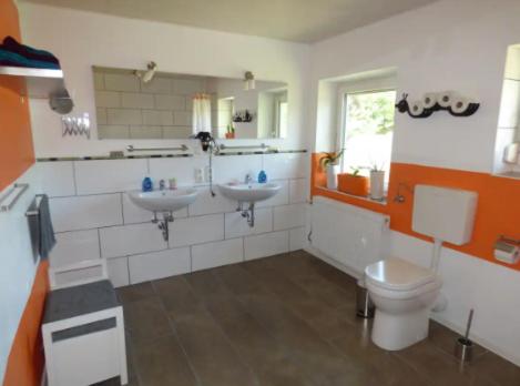 un bagno con due lavandini e un WC di Ferienwohnung Waldblick Schönbronn a Buch am Wald