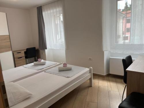 a white bedroom with a bed with two pillows on it at Villa Ivanka in Koper