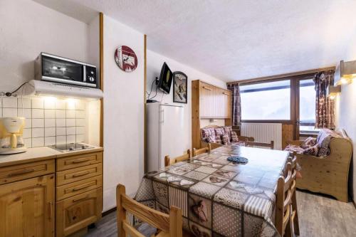 une petite cuisine avec une table et un réfrigérateur dans l'établissement Résidence Le Plein Sud Centre - 2 Pièces 5 pers - Résidence Le Plein Sud - PLAGNE CENTRE MAE-6014, à Aime La Plagne