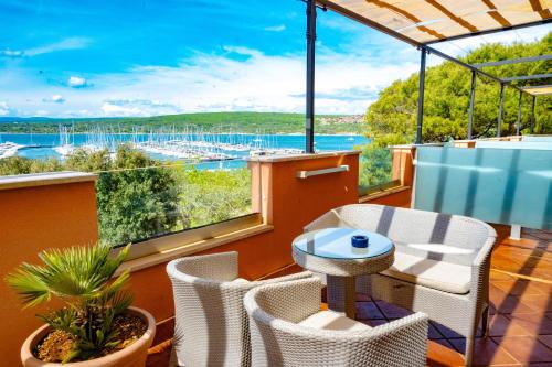 a balcony with a table and chairs and a view of the water at Hotel Kanajt in Punat