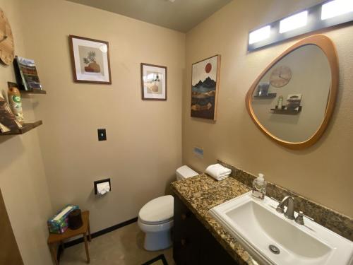 a bathroom with a sink and a toilet and a mirror at PNW MCM 155ft Private Waterfront Gem on Raft Island with Hot Tub in Gig Harbor