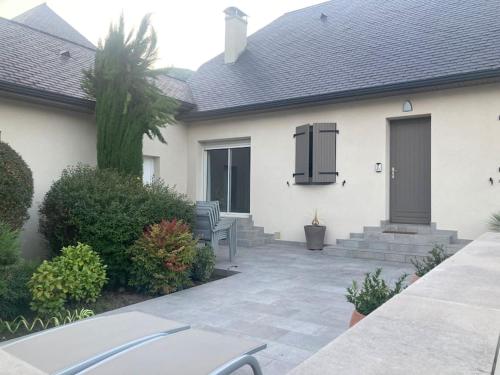 une maison avec un patio avec des chaises et des plantes dans l'établissement La maison de Marie, à Argelès-Gazost