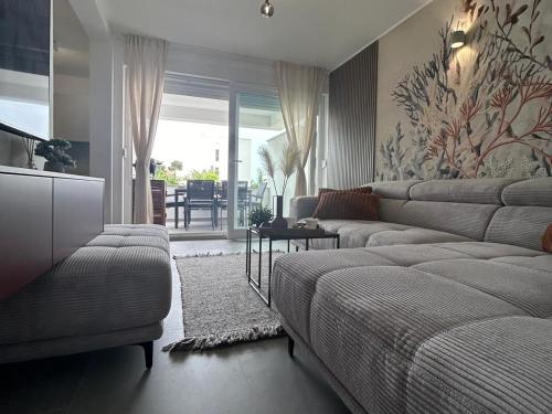 a living room with a bed and a couch at Luxury apartment Terracotta Sun with private Jacuzzi and Garden in Novalja