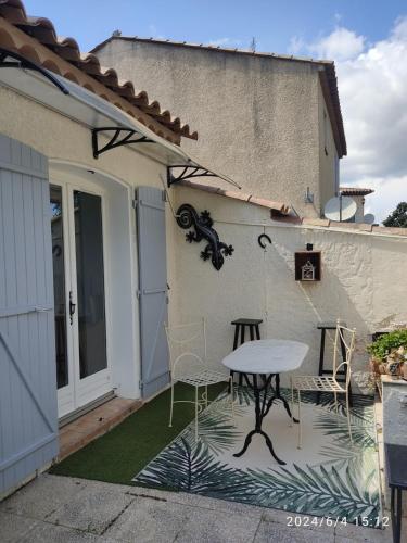 un patio avec une table et des chaises à côté d'un bâtiment dans l'établissement Studio climatisé avec spa privatif, à Fréjus