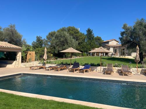 une piscine avec chaises et parasols dans une cour dans l'établissement Valbonne House in Provencal style, à Valbonne