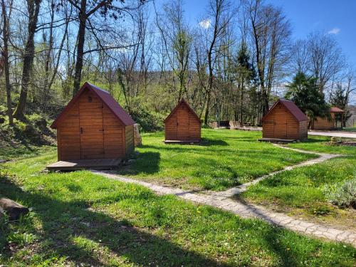 a group of three small buildings in the grass at Koča sredi gozda in Kanal