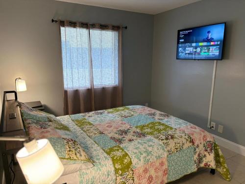 a bedroom with a bed and a flat screen tv at Coastal Breeze - 2BR Apartment in West Palm Beach