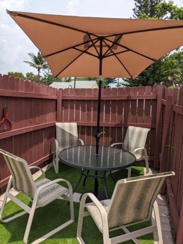 a patio with a table and chairs and an umbrella at Coastal Breeze - 2BR Apartment in West Palm Beach