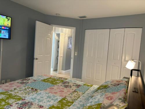 a bedroom with a bed and a flat screen tv at Coastal Breeze - 2BR Apartment in West Palm Beach
