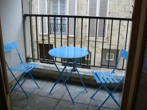 - deux chaises bleues et une table sur un balcon dans l'établissement L'appartement du Lys, à Périgueux