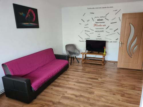 a living room with a purple couch and a tv at Eva Apartments Mall 90mp in Bacău