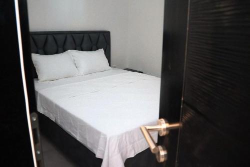 a bed with white sheets and a black headboard at Zen Oaza in Konjic