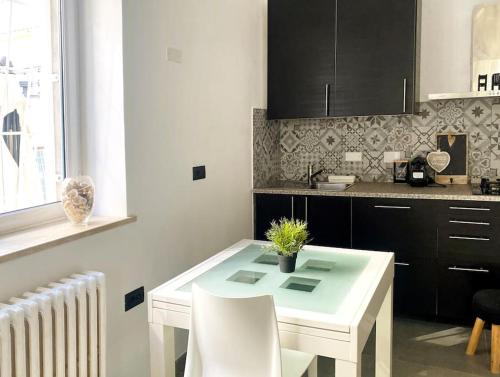 a kitchen with a white table and white chairs at Lemon tree 400 mt dal mare in Nettuno