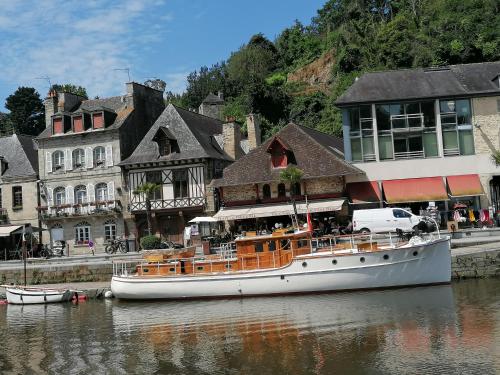 un bateau assis dans l'eau devant les bâtiments dans l'établissement La Tocade Del Arte - Dinan, à Lanvallay