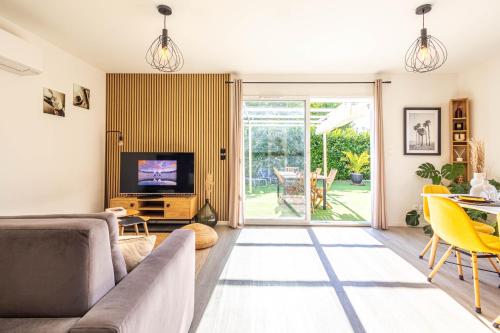 un salon avec un canapé et une télévision dans l'établissement VILLA RIO - Maison avec jardin proche Bordeaux !, à Villenave-dʼOrnon