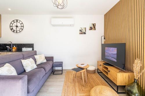 un salon avec un canapé violet et une télévision dans l'établissement VILLA RIO - Maison avec jardin proche Bordeaux !, à Villenave-dʼOrnon