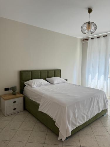 a bedroom with a large bed with a green headboard at Smart Rent Apartments 2 in Tirana