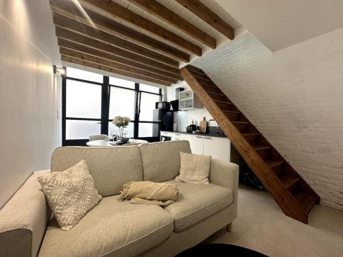 un salon avec un canapé et un escalier dans l'établissement Gare Unique Duplex lumineux, à Amiens