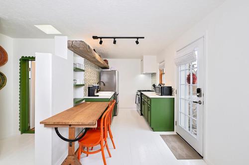 a kitchen with a wooden table and green cabinets at Dos Hermanas Casita 1 Downtown Courtyard in Santa Fe