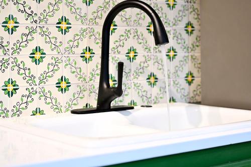 a white sink with a black faucet in a bathroom at Dos Hermanas Casita 1 Downtown Courtyard in Santa Fe