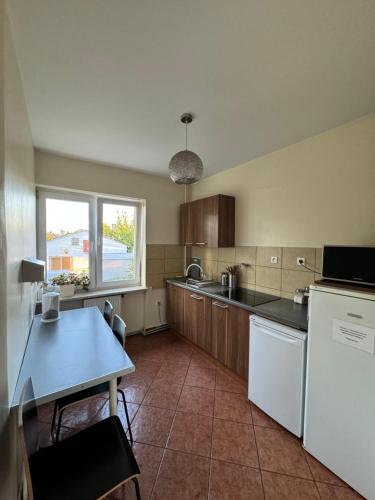 a kitchen with a white refrigerator and a table at ANNA NOCLEGI in Raszyn