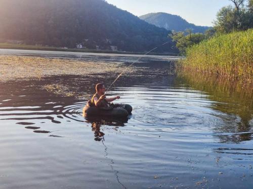 a man sitting in a raft in the water fishing at Drinska bajka in Mali Zvornik