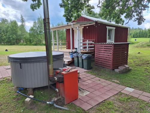 a small red house with trash cans in front of it at Toma pirts MAZĀ in Ikšķile