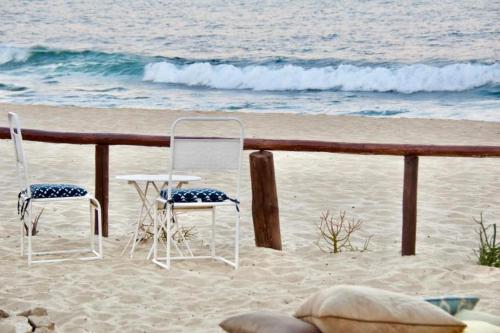 two chairs and a table in the sand on the beach at RUSTICO LOUNGE-Tipi With AC in front of the beach in San José del Cabo