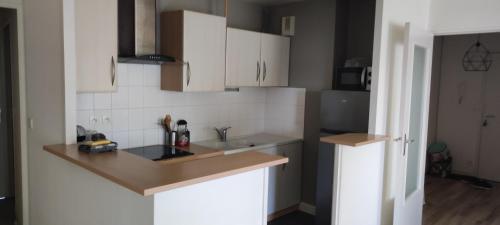 une cuisine avec des armoires blanches et un évier dans l'établissement superbe appartement centre ville saint grégoire, à Saint-Grégoire