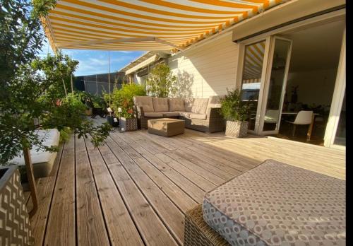 a wooden deck with a couch and an umbrella at Limmatspitz - private room - shared apartment in Gebenstorf