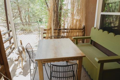 a table and chairs in a room with a dog at Tesuque Outpost Casita F Best views in Santa Fe in Santa Fe