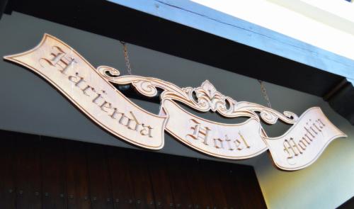 a sign for a restaurant hanging from a building at Hacienda Montija Hotel in Huelva