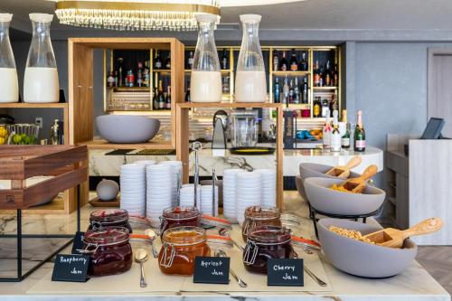 a counter with jars of honey and plates of food at Crowne Plaza Constanta - Mamaia Beach by IHG in Mamaia