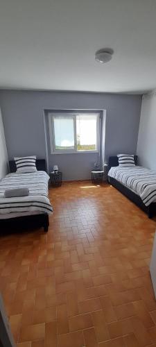 deux lits dans une chambre avec parquet dans l'établissement Agréable appartement de 80M2 dans Maison, à Lourdes