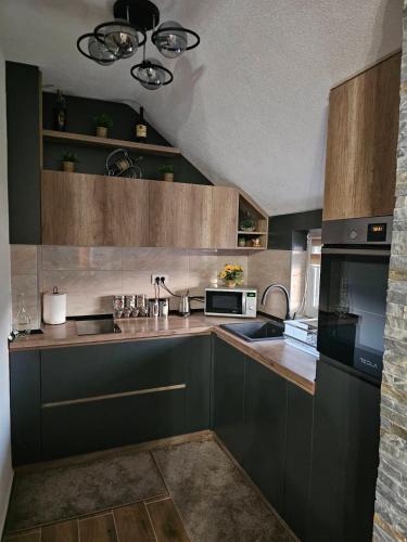 a kitchen with a sink and a stove at SOUL Apartman in Soko Banja