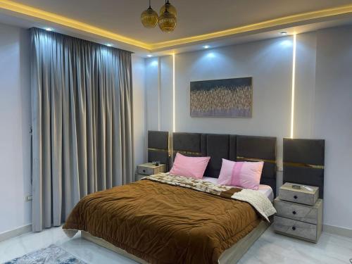 ein Schlafzimmer mit einem großen Bett mit rosa Kissen in der Unterkunft شقة فندقية غرفتين بكمبوند قرب ميدان جهينة in Sheikh Zayed