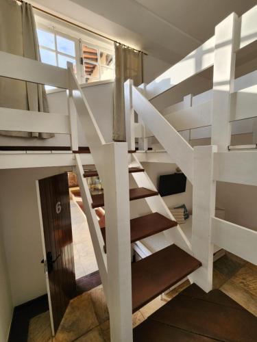 a white staircase in a tiny house with a window at Pousada Dreamland Buzios in Búzios