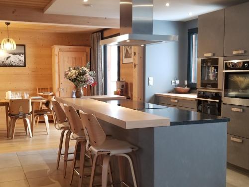 a kitchen with a large island with bar stools at Chalet Walser à VALLORCINE 13 kms CHAMONIX France in Vallorcine
