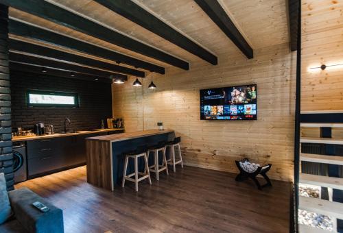 a kitchen with a bar and a tv on the wall at Kazbegi Hills Cottages in Stepantsminda