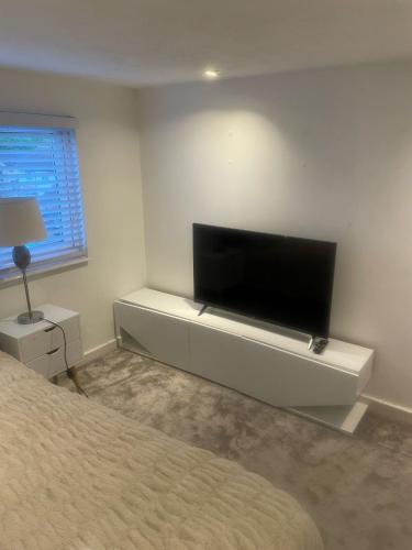 a bedroom with a flat screen tv on a wall at Room in Cheshunt in Cheshunt